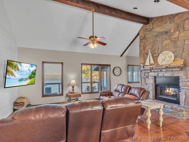 living room featuring a fireplace, wood-type flooring, vaulted ceiling with beams, and ceiling fan