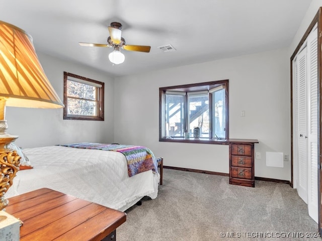 carpeted bedroom featuring a closet and ceiling fan