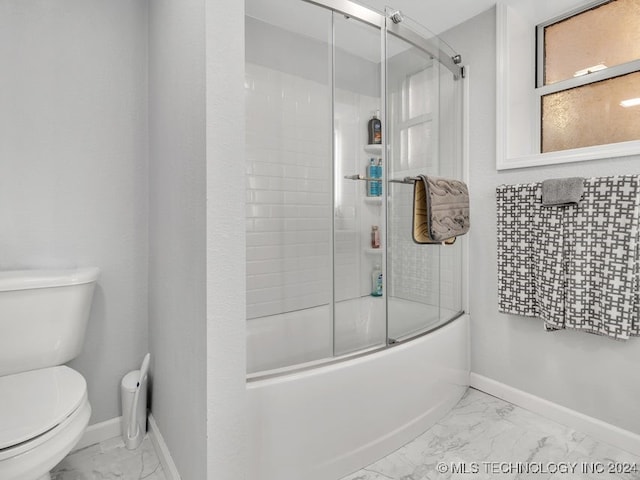 bathroom featuring toilet and combined bath / shower with glass door