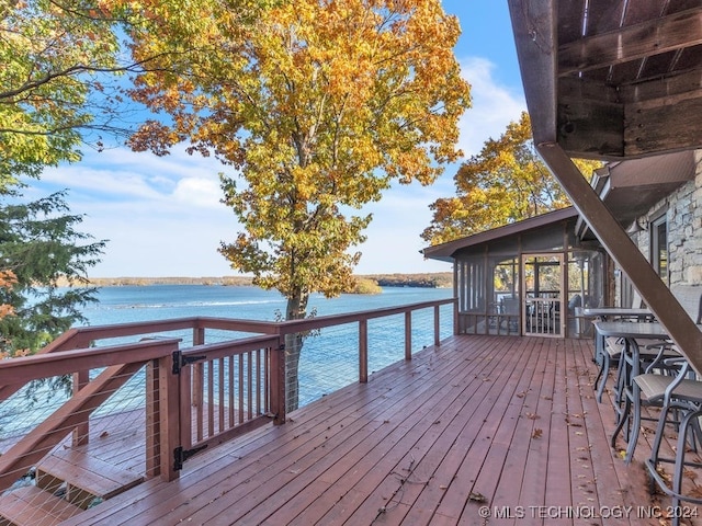 wooden terrace featuring a sunroom and a water view