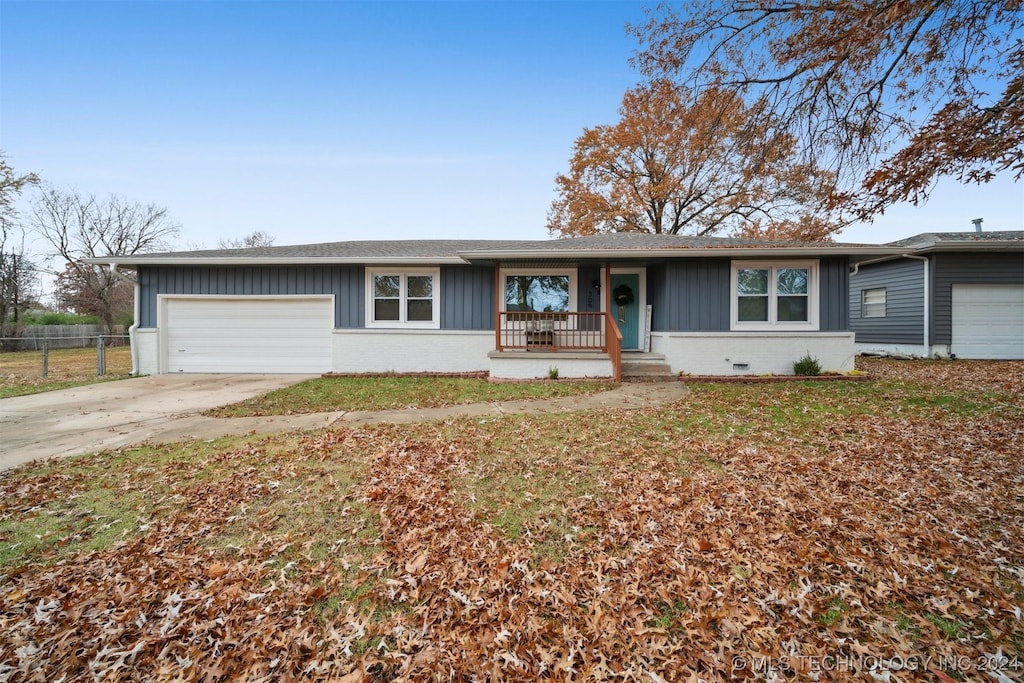 single story home featuring a porch and a garage