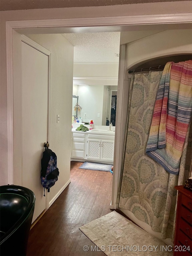 bathroom with hardwood / wood-style flooring, vanity, and a textured ceiling