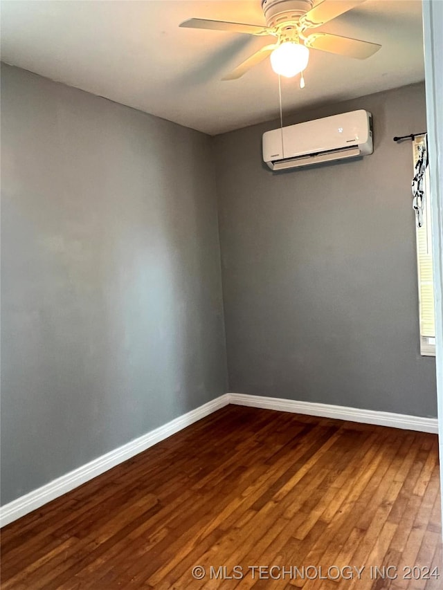 empty room featuring ceiling fan, a wall mounted air conditioner, and hardwood / wood-style flooring