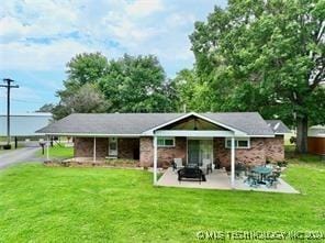 rear view of property with a patio area and a yard