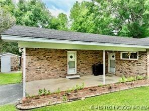 view of front facade featuring a front lawn and a storage shed