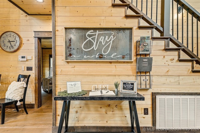 interior space with hardwood / wood-style flooring and wood walls