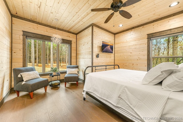 bedroom with wood walls and multiple windows