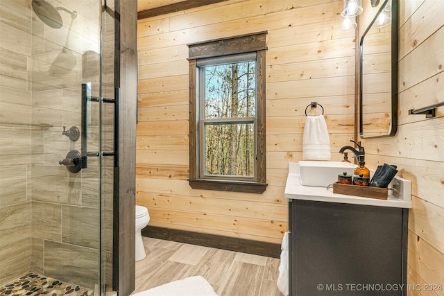 bathroom featuring vanity, wood walls, and toilet