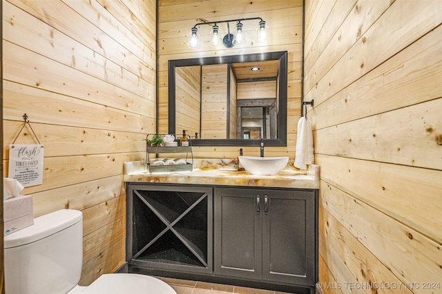 bathroom with wood walls, vanity, and toilet