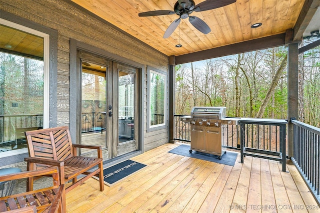 wooden terrace with ceiling fan and a grill