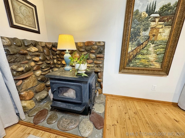 details with wood-type flooring and a wood stove