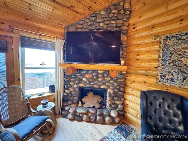 living area with rustic walls, wood ceiling, vaulted ceiling, hardwood / wood-style floors, and a stone fireplace