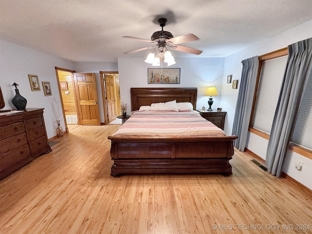 bedroom featuring a textured ceiling, light wood-type flooring, and ceiling fan