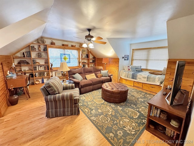 living room with wooden walls, ceiling fan, vaulted ceiling, and hardwood / wood-style flooring