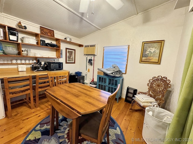 dining room featuring a wall unit AC, ceiling fan, vaulted ceiling, and light wood-type flooring