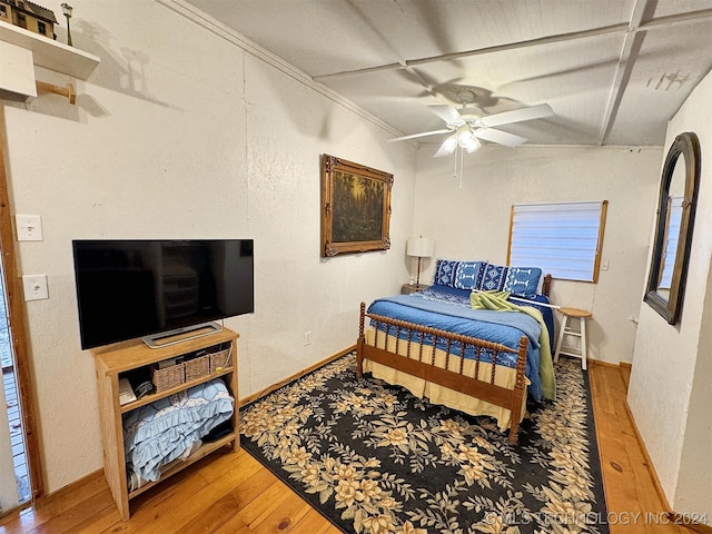 bedroom with wood-type flooring, ceiling fan, and ornamental molding