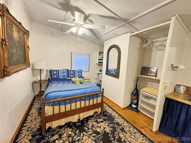 bedroom featuring ceiling fan, hardwood / wood-style floors, and vaulted ceiling