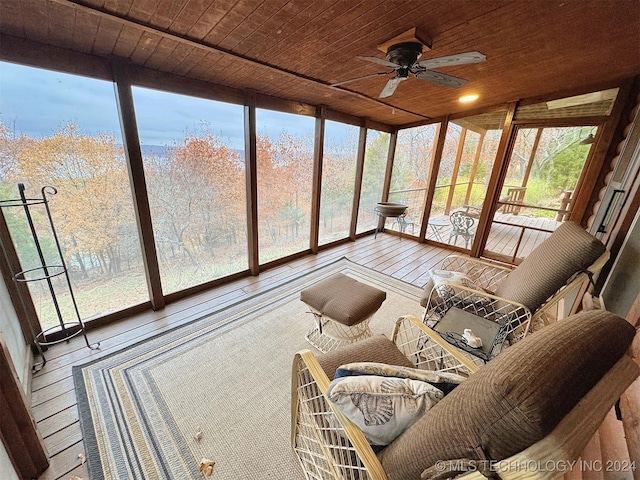 sunroom with ceiling fan, a wealth of natural light, and wood ceiling