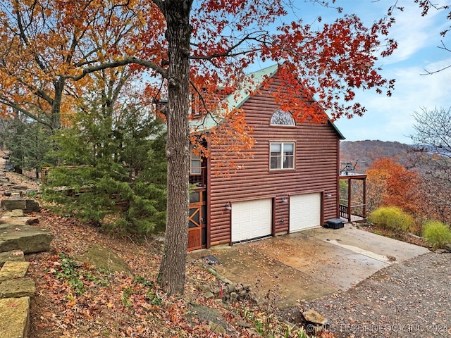 view of side of home featuring a mountain view and a garage