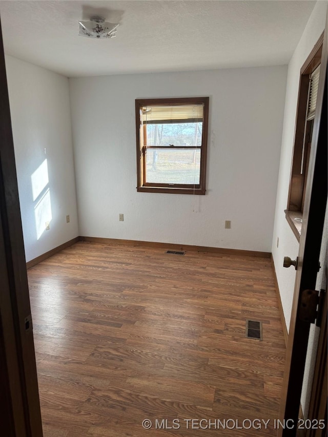 spare room with dark hardwood / wood-style floors