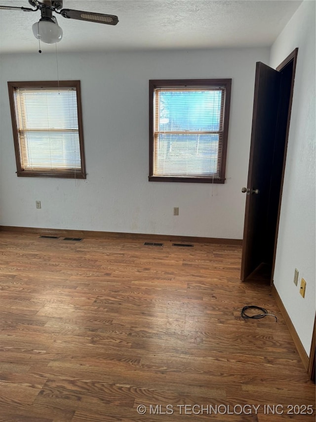 unfurnished room with ceiling fan and dark hardwood / wood-style flooring