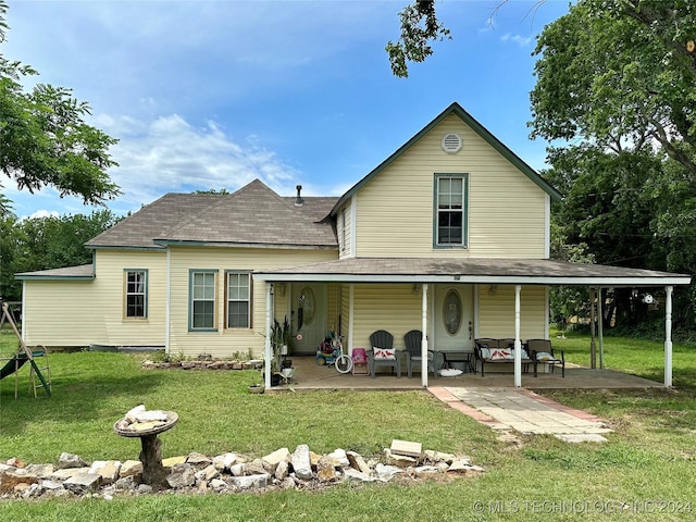 rear view of house featuring a yard and a patio