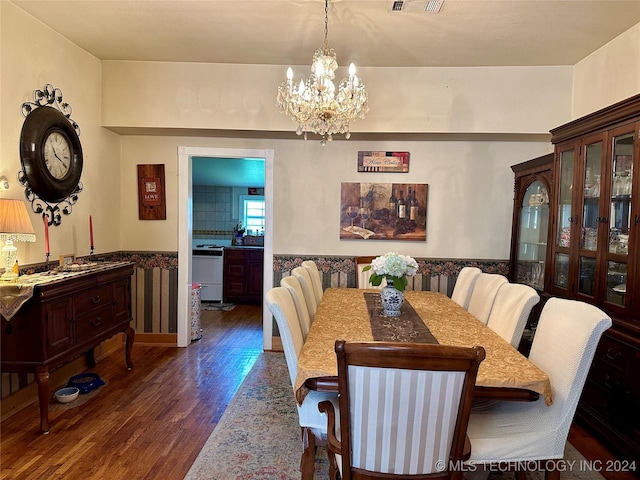 dining area with dark hardwood / wood-style floors and a notable chandelier