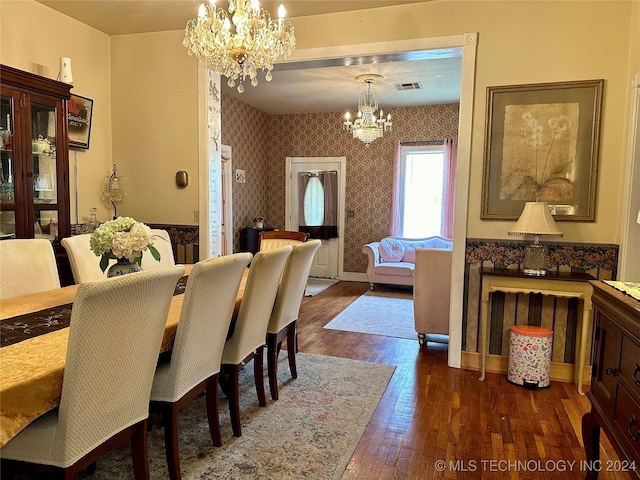 dining area with dark hardwood / wood-style flooring and a notable chandelier