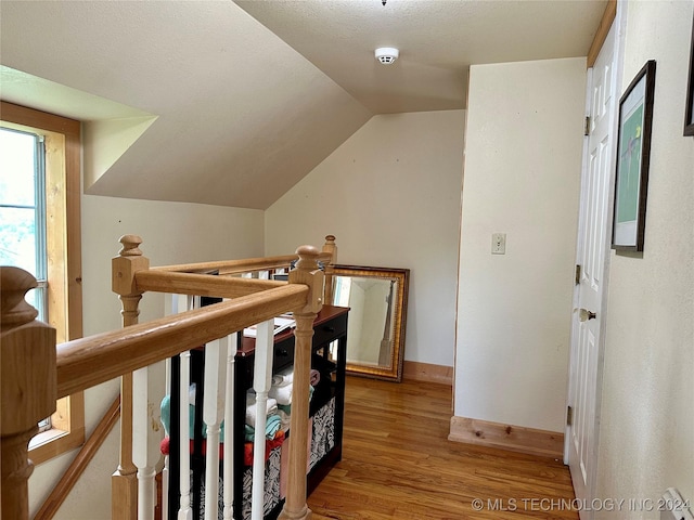 interior space with hardwood / wood-style flooring and vaulted ceiling