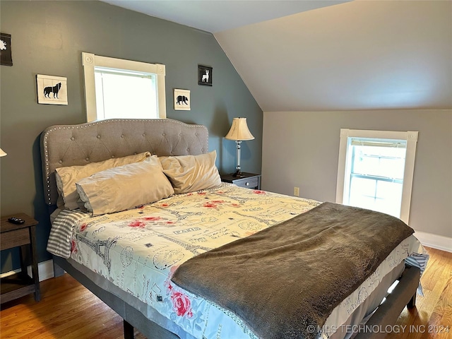 bedroom featuring hardwood / wood-style floors and lofted ceiling