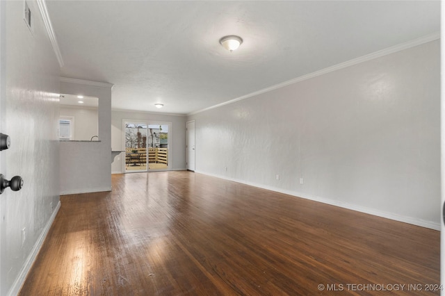 empty room with dark hardwood / wood-style floors and crown molding