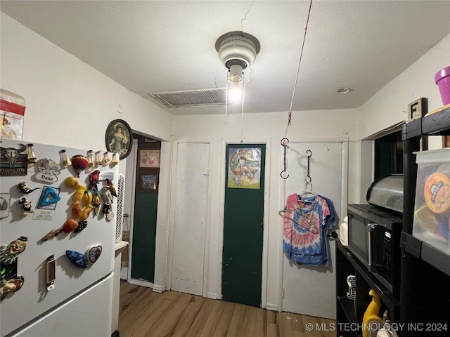 kitchen featuring white refrigerator and hardwood / wood-style flooring