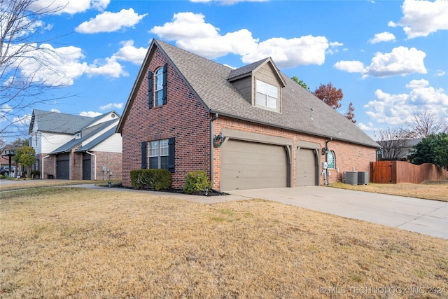 view of side of home with a lawn, cooling unit, and a garage