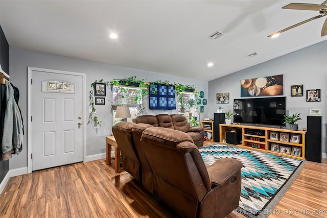 living room featuring hardwood / wood-style flooring, ceiling fan, and vaulted ceiling