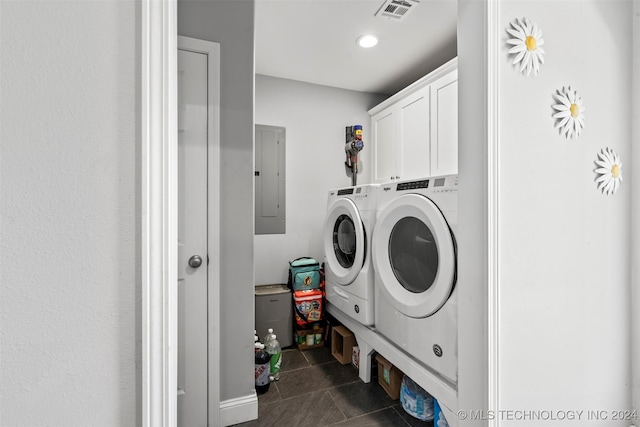 laundry room featuring cabinets, electric panel, and washer and clothes dryer