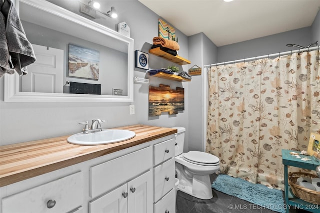 bathroom featuring vanity, curtained shower, tile patterned floors, and toilet