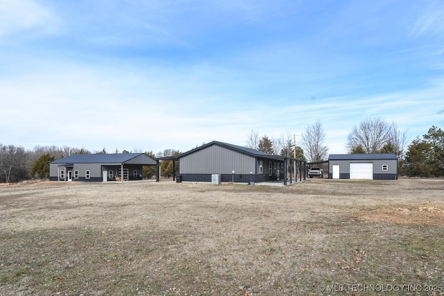 ranch-style home featuring a garage, an outdoor structure, and a front lawn