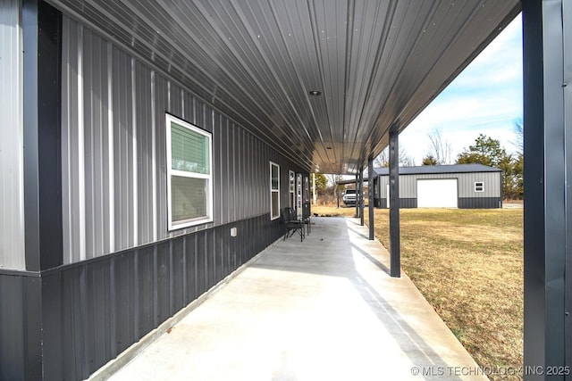 view of side of home with a garage, a patio area, and a lawn