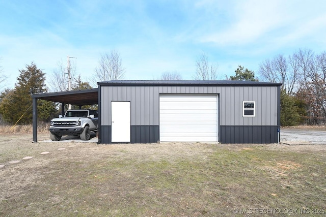 garage with a carport and a lawn