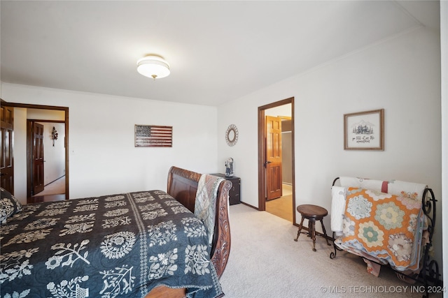 carpeted bedroom with connected bathroom and crown molding