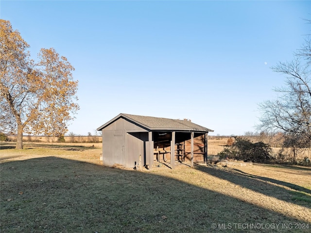 view of outdoor structure with a yard and a rural view