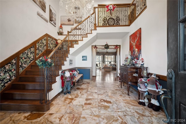 foyer entrance featuring a chandelier and a towering ceiling