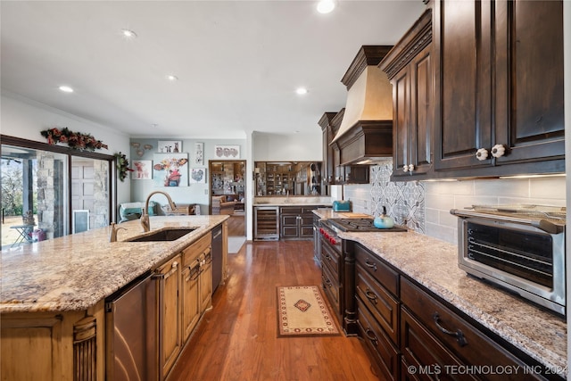 kitchen with dark wood-type flooring, sink, a center island with sink, dishwasher, and wine cooler