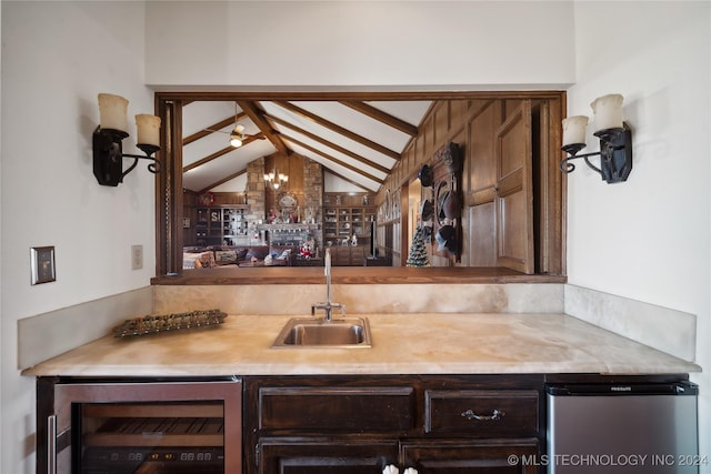 bar featuring ceiling fan, sink, beverage cooler, and lofted ceiling