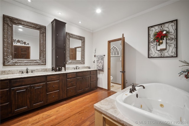 bathroom featuring vanity, crown molding, toilet, a tub to relax in, and wood-type flooring