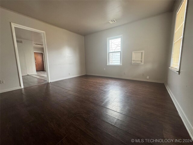 unfurnished room with dark wood-type flooring