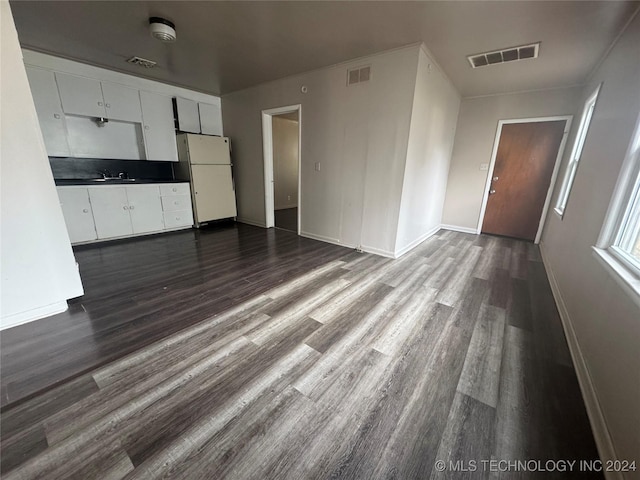 unfurnished living room featuring dark hardwood / wood-style flooring and sink