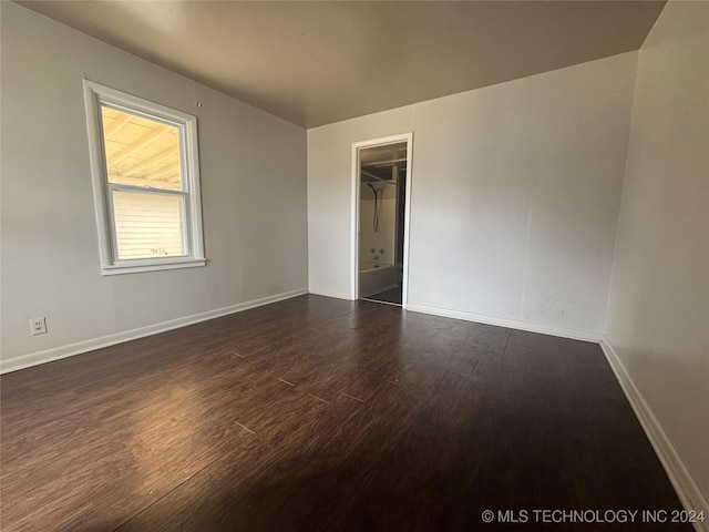 unfurnished room featuring dark wood-type flooring