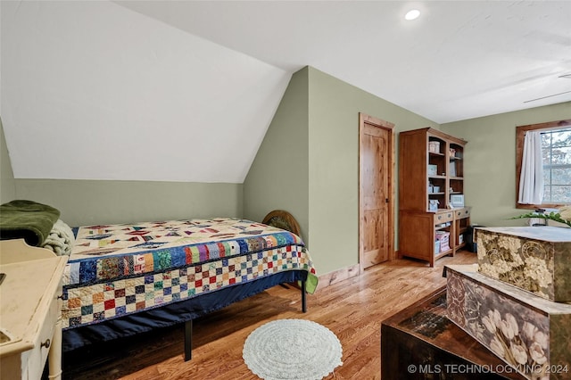 bedroom with light wood-type flooring and lofted ceiling