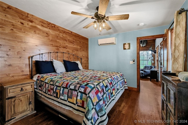 bedroom with a wall mounted air conditioner, ceiling fan, dark wood-type flooring, and wood walls